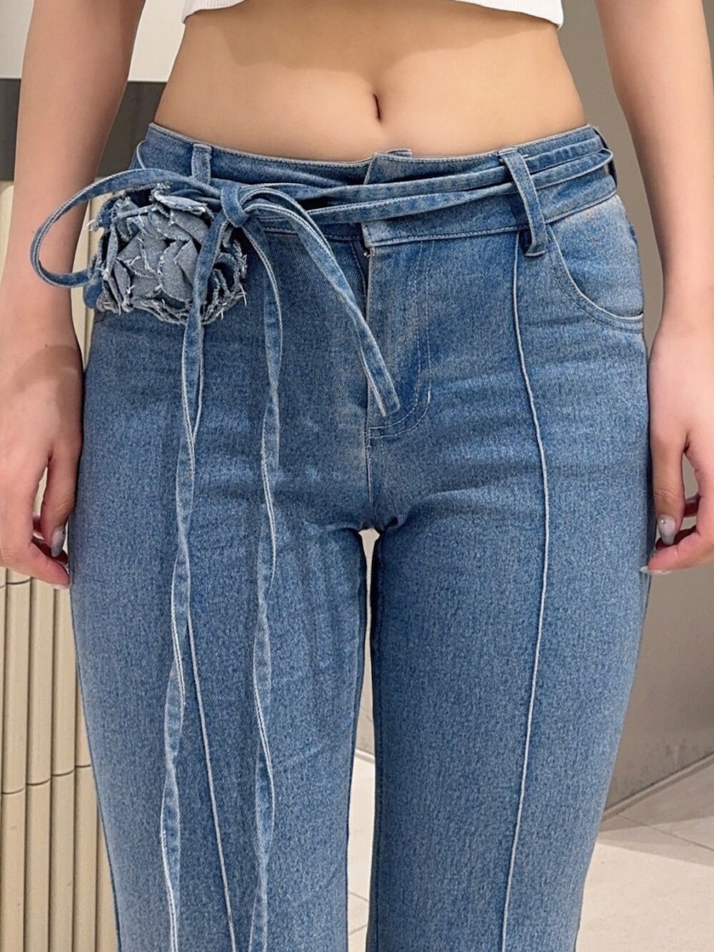 ブラック系のサンダル、ブルー系のタンクトップ、ブルー系のデニムパンツを着用したレディースの夏コーディネートの5枚目の写真