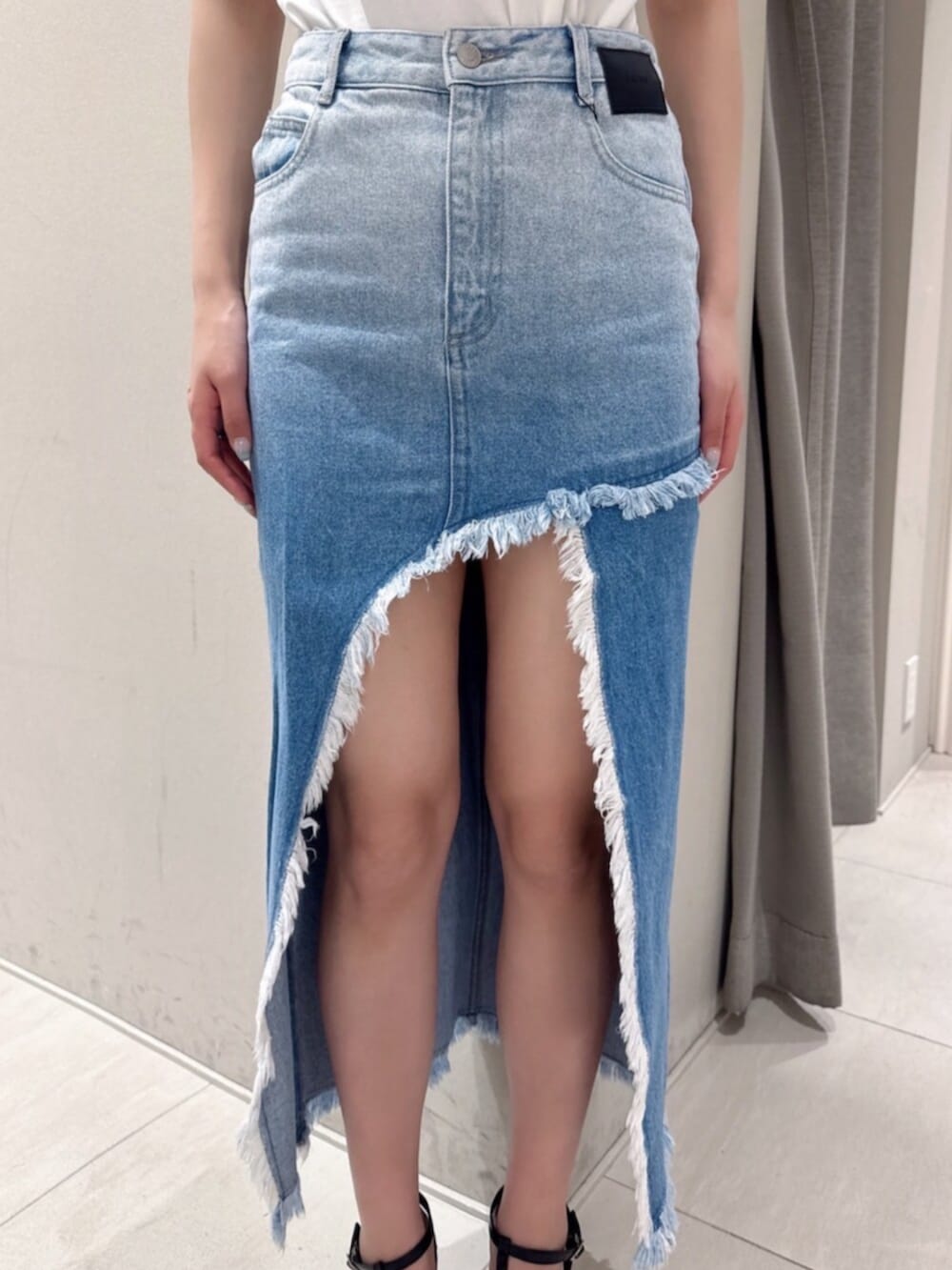 ブラック系のサンダル、ホワイト系のTシャツ/カットソー、ブルー系のデニムスカートを着用したレディースの夏コーディネートの5枚目の写真