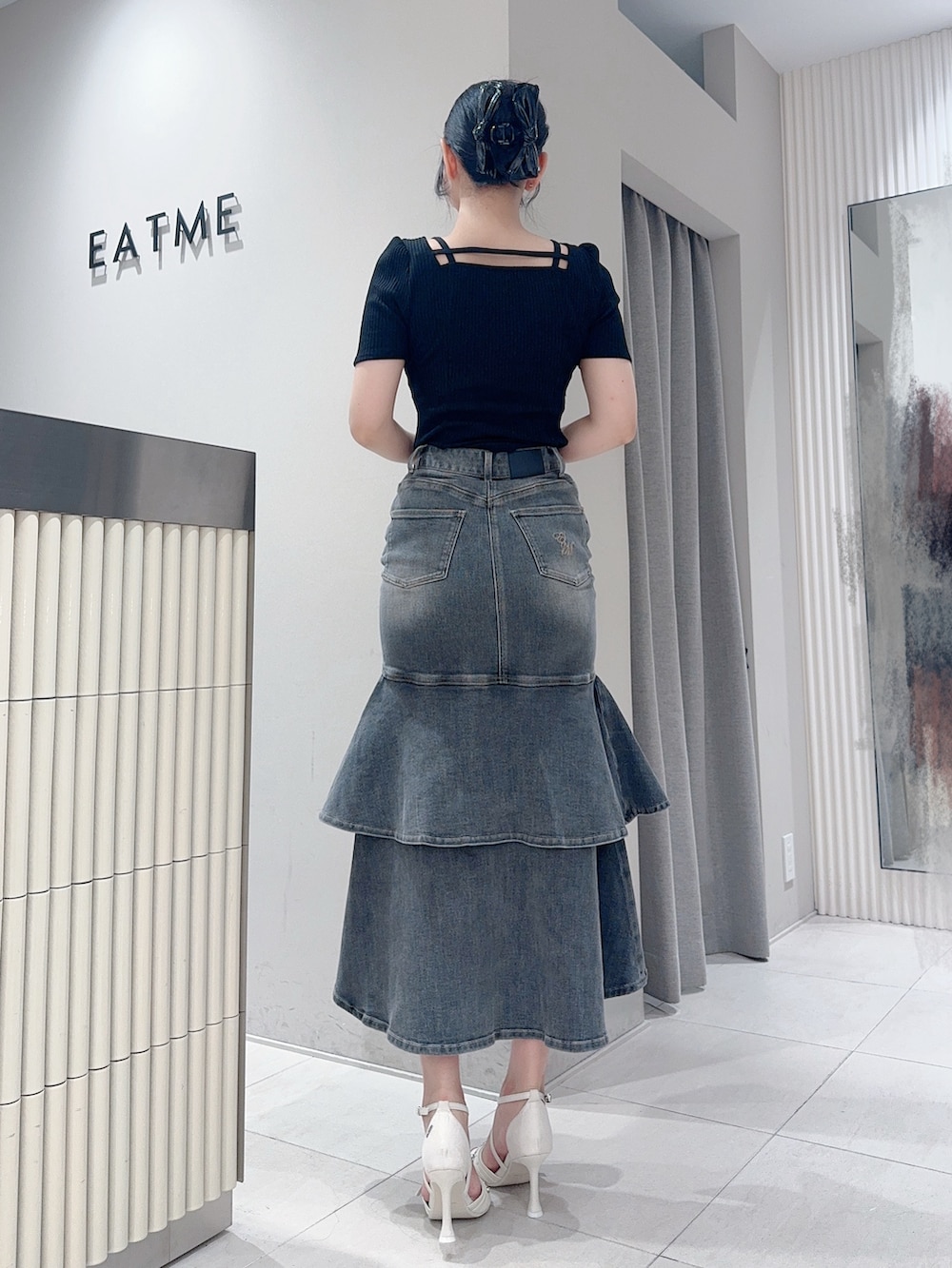 ブラック系のTシャツ/カットソー、ブラック系のデニムスカート、ホワイト系のサンダルを着用したレディースの夏コーディネートの3枚目の写真