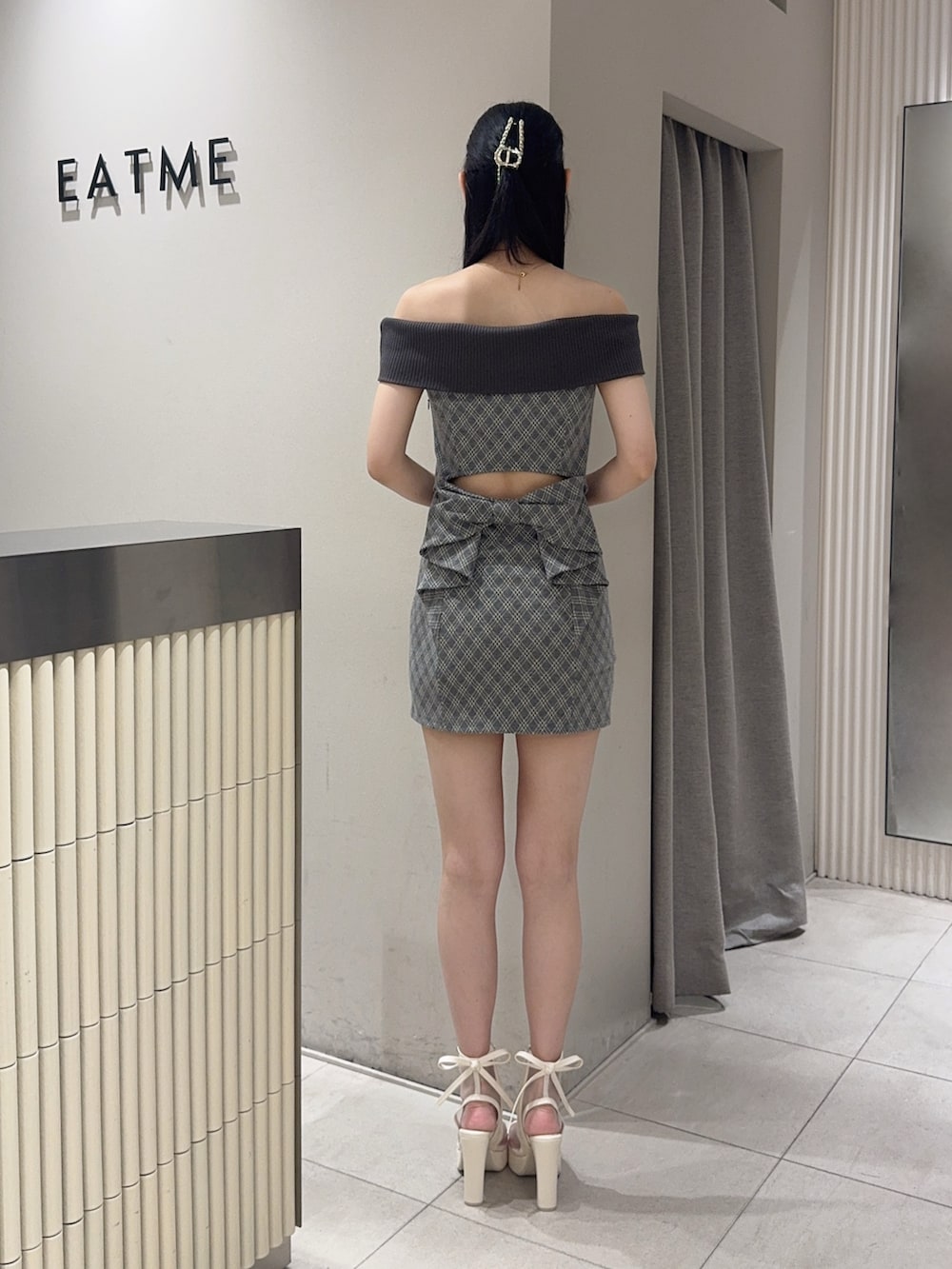 グレー系のワンピース、ホワイト系のサンダル、ゴールド系のネックレスを着用したレディースの夏コーディネートの3枚目の写真