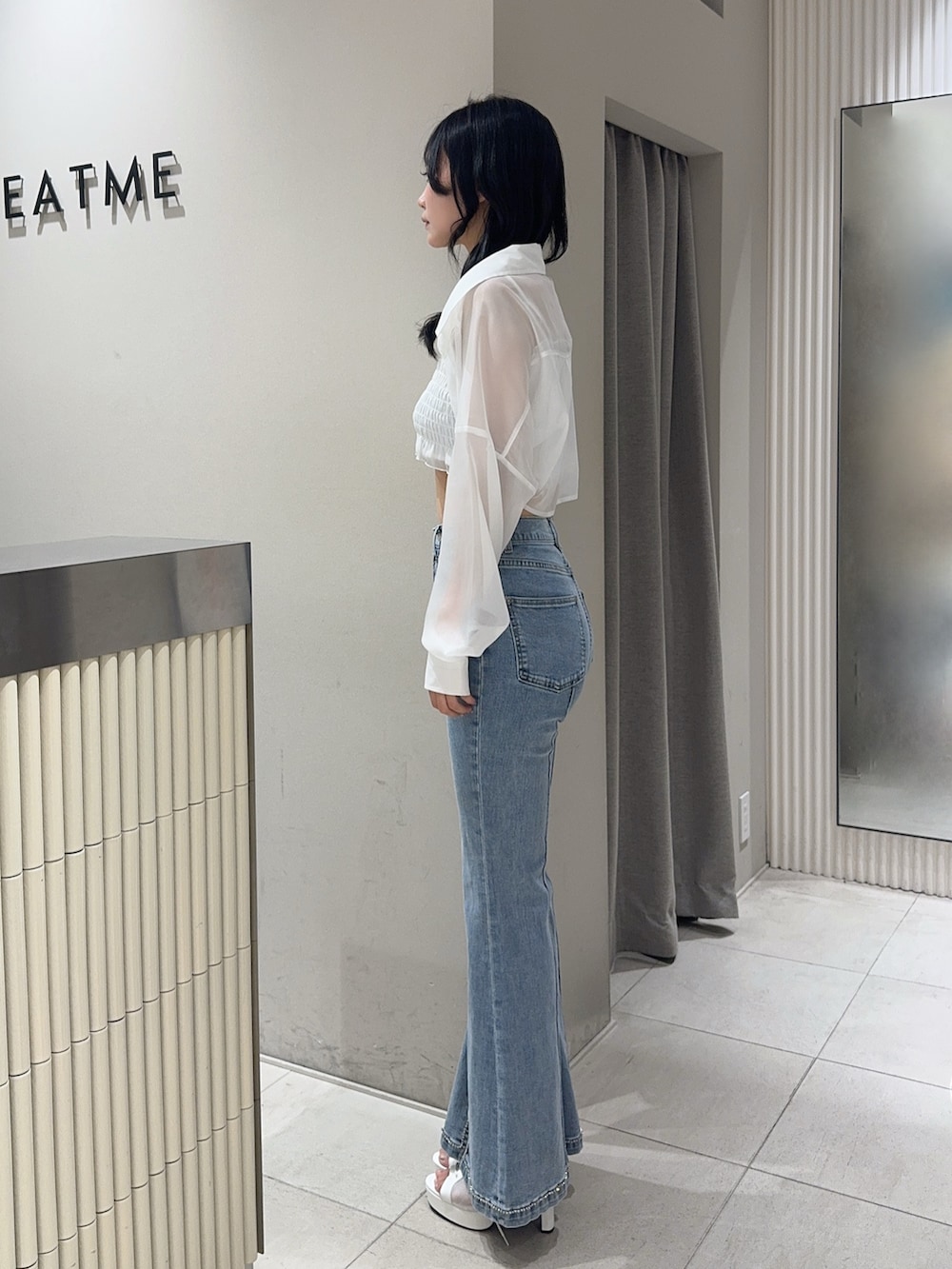 ブルー系のデニムパンツ、ホワイト系のブーツ、ホワイト系のシャツ/ブラウスを着用したレディースの春コーディネートの2枚目の写真