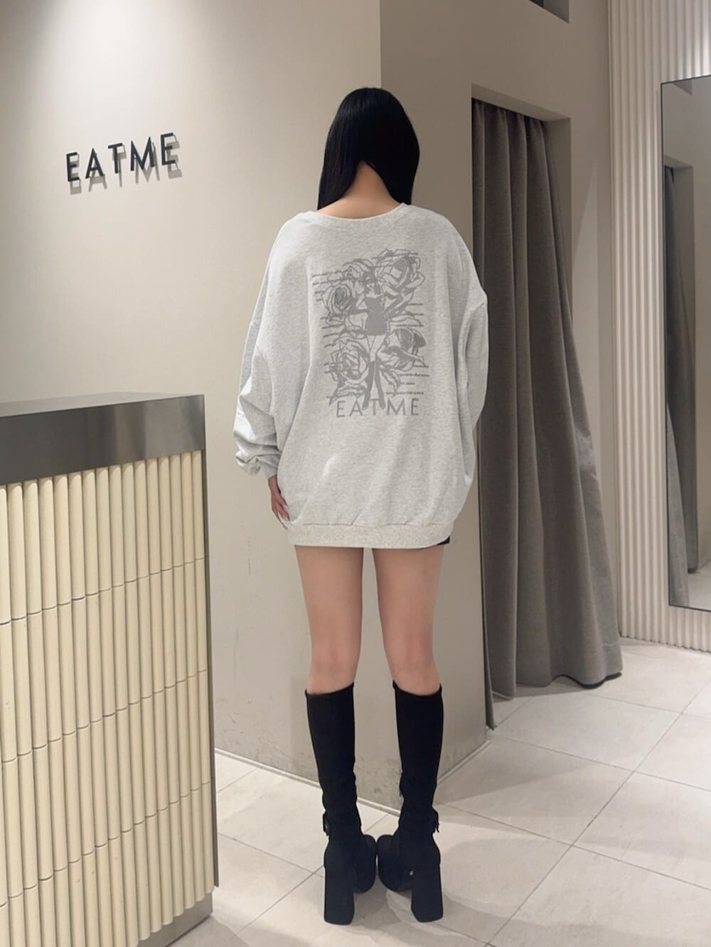 ブラック系のデニムスカート、ブラック系のブーツ、グレー系のスウェットを着用したレディースの秋コーディネートの3枚目の写真