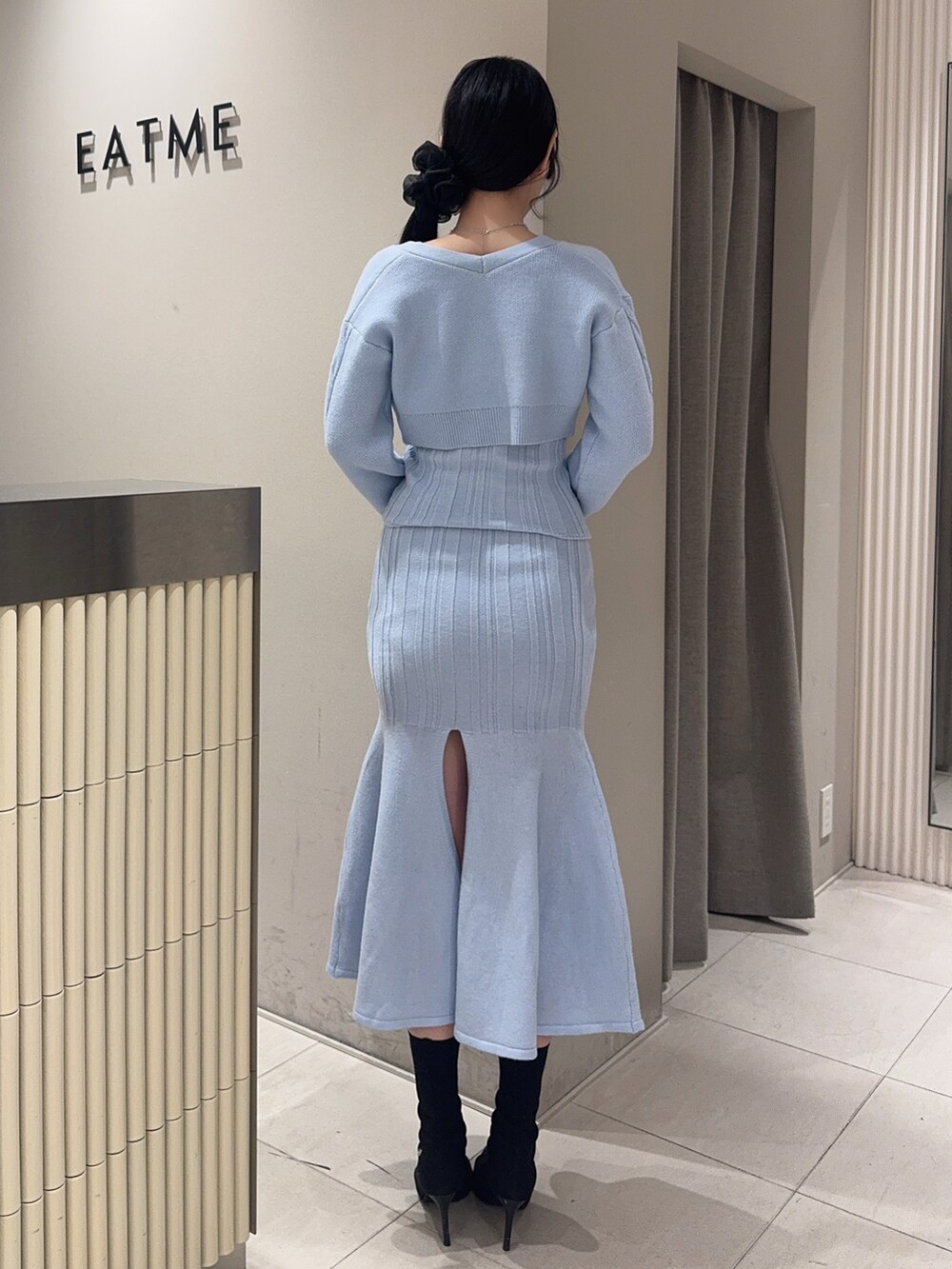 ブルー系のニット/セーター、ブルー系のスカート、ブラック系のブーツを着用したレディースの冬コーディネートの3枚目の写真