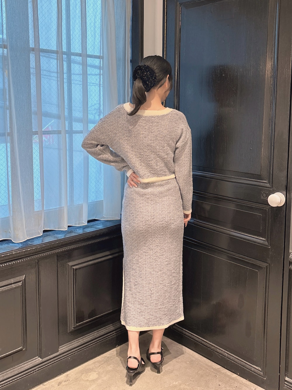 ブルー系のカーディガン/ボレロ、ブルー系のスカート、ブラック系のパンプスを着用したレディースの冬コーディネートの3枚目の写真