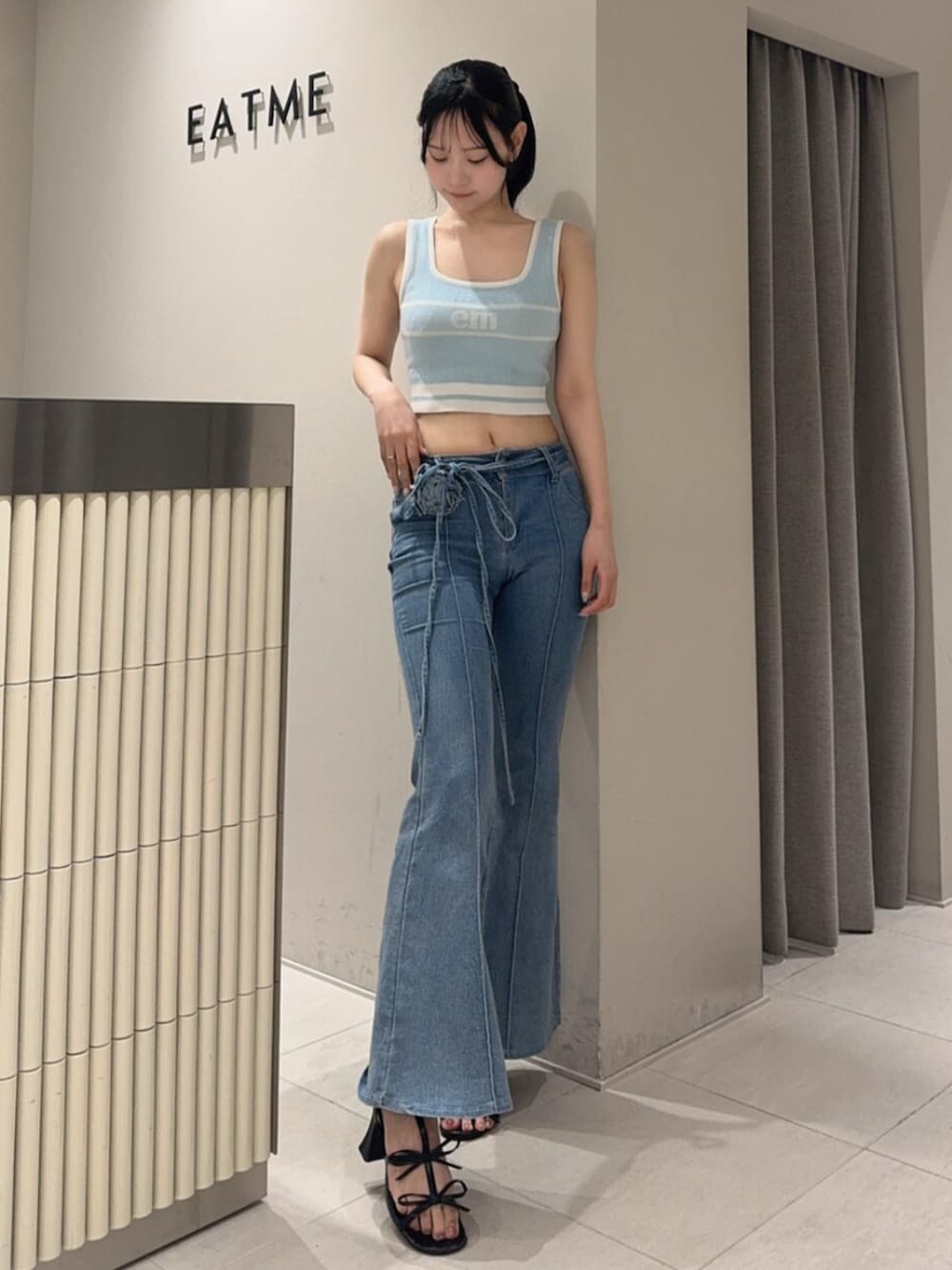 ブラック系のサンダル、ブルー系のタンクトップ、ブルー系のデニムパンツを着用したレディースの夏コーディネートの2枚目の写真