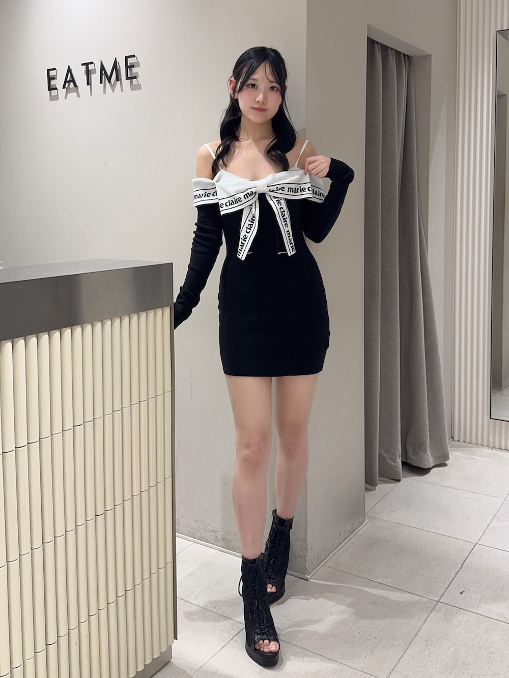 ブラック系のワンピース、ブラック系のハンドバッグ、ブラック系のブーツを着用したレディースの春コーディネートの4枚目の写真