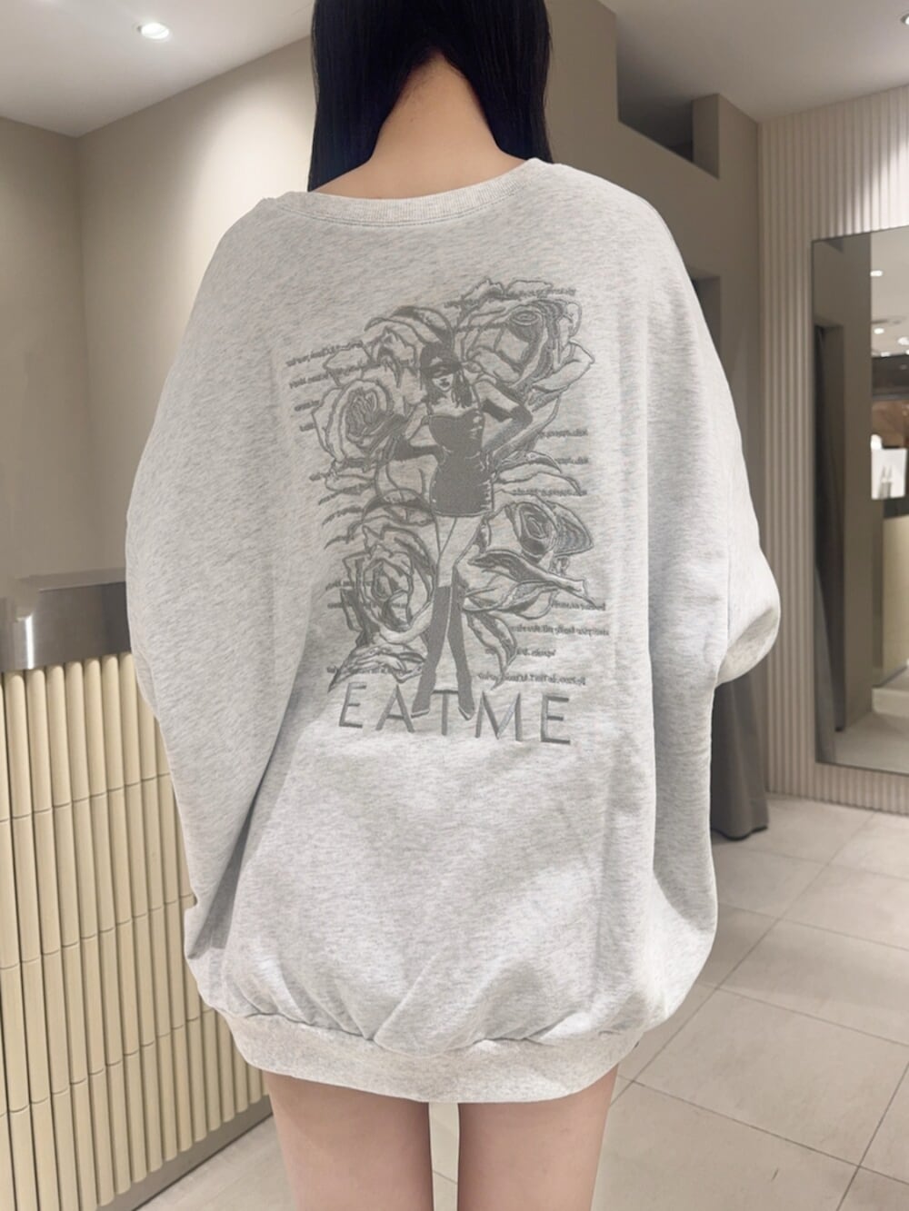 ブラック系のデニムスカート、ブラック系のブーツ、グレー系のスウェットを着用したレディースの秋コーディネートの5枚目の写真