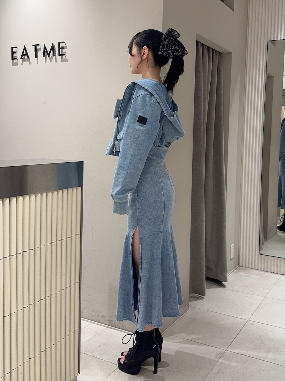 ブルー系のワンピース、ブルー系のパーカー、ブラック系のブーツを着用したレディースの春コーディネートの2枚目の写真