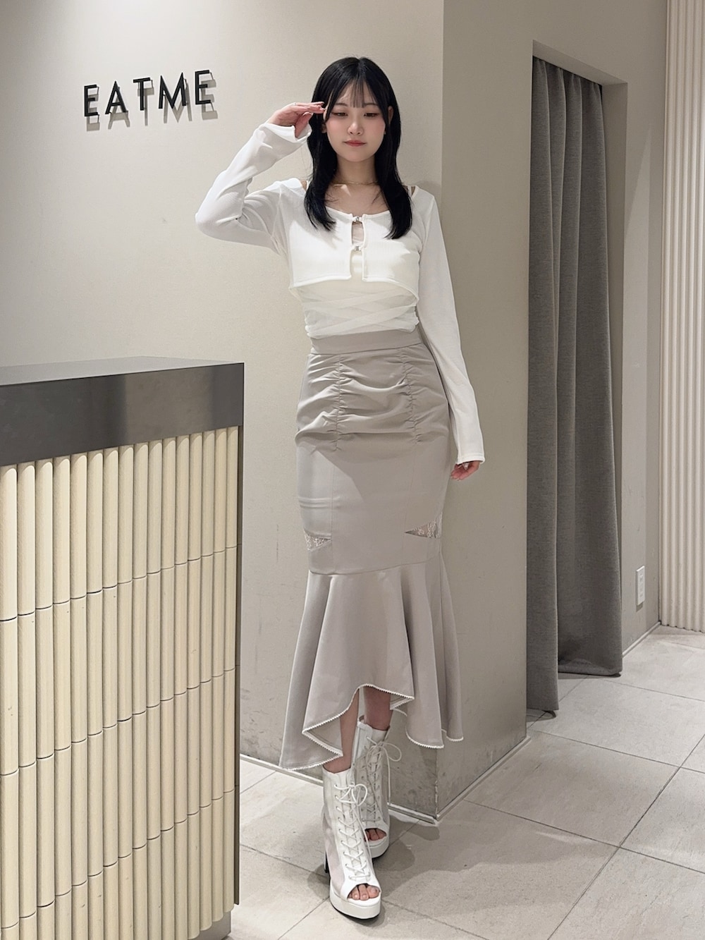 グレー系のスカート、ホワイト系のTシャツ/カットソー、ホワイト系のブーツを着用したレディースの春コーディネートの5枚目の写真