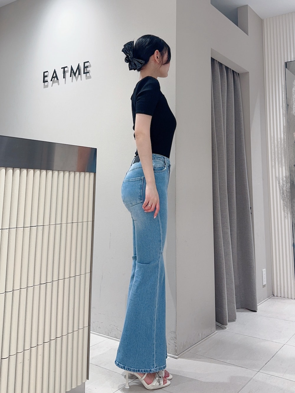 ブラック系のTシャツ/カットソー、ブルー系のデニムパンツ、ホワイト系のサンダルを着用したレディースの夏コーディネートの2枚目の写真