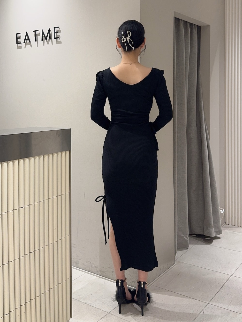 ブラック系のワンピース、ホワイト系のハンドバッグ、ブラック系のサンダルを着用したレディースの春コーディネートの3枚目の写真