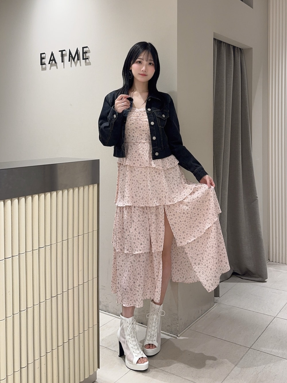 ピンク系のワンピース、ブラック系のデニムジャケット、ホワイト系のブーツを着用したレディースの春コーディネートの4枚目の写真