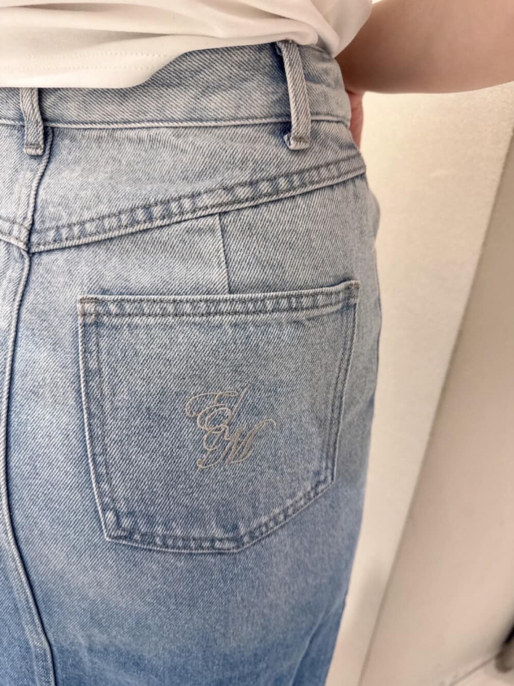 ブラック系のサンダル、ホワイト系のTシャツ/カットソー、ブルー系のデニムスカートを着用したレディースの夏コーディネートの4枚目の写真