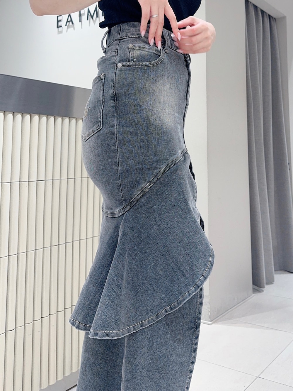 ブラック系のTシャツ/カットソー、ブラック系のデニムスカート、ホワイト系のサンダルを着用したレディースの夏コーディネートの5枚目の写真