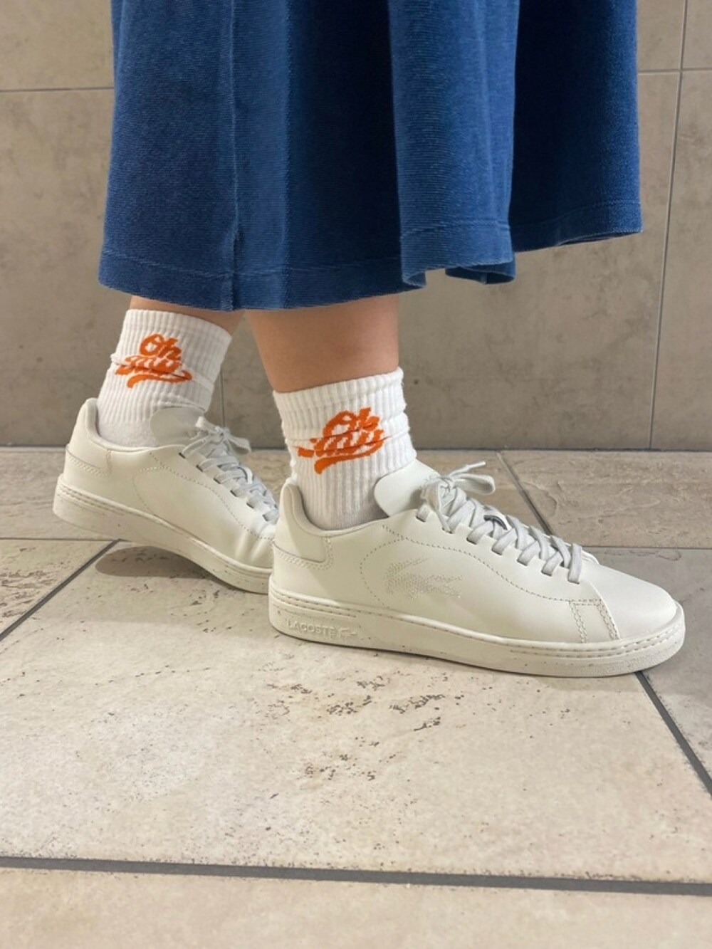 ブルー系のワンピース、ピンク系のショルダーバッグ、ホワイト系のスニーカーを着用したレディースの春コーディネートの5枚目の写真