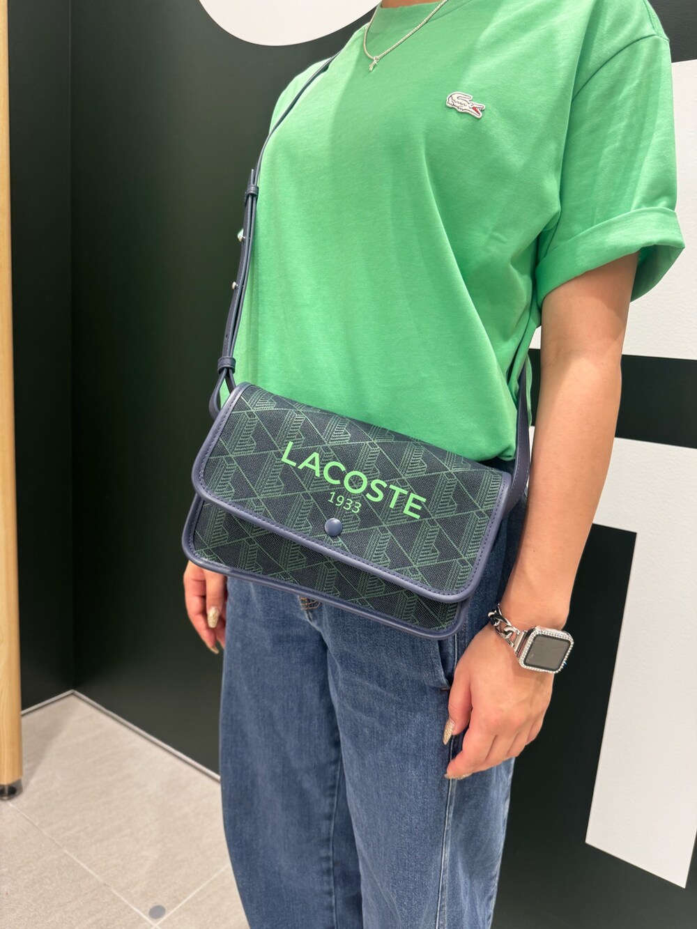 グリーン系のTシャツ/カットソー、ブルー系のデニムパンツ、ホワイト系のスニーカーを着用したレディースの夏コーディネートの5枚目の写真