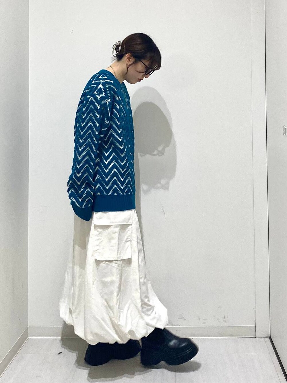 ブラック系のブーツ、ホワイト系のスカート、ブルー系のニット/セーターを着用したレディースの冬コーディネートの4枚目の写真