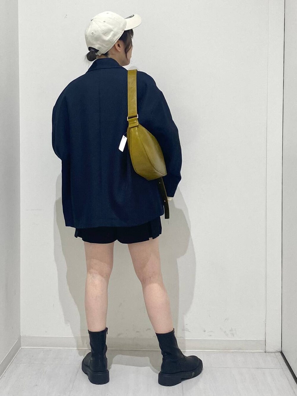 ブルー系のテーラードジャケット、ホワイト系のニット/セーター、イエロー系のショルダーバッグを着用したレディースの冬コーディネートの3枚目の写真