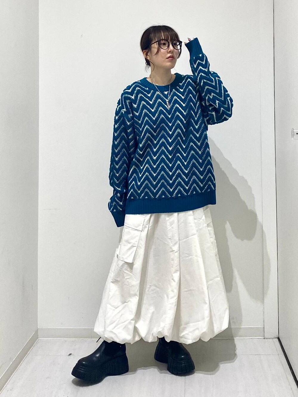 ブラック系のブーツ、ホワイト系のスカート、ブルー系のニット/セーターを着用したレディースの冬コーディネートの6枚目の写真