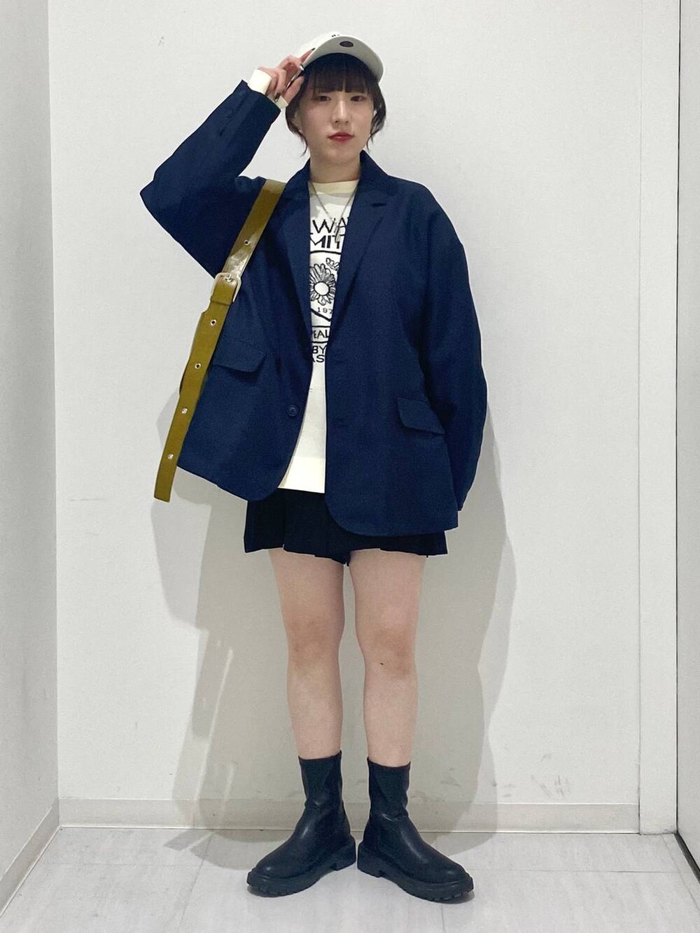 ブルー系のテーラードジャケット、ホワイト系のニット/セーター、イエロー系のショルダーバッグを着用したレディースの冬コーディネートの6枚目の写真