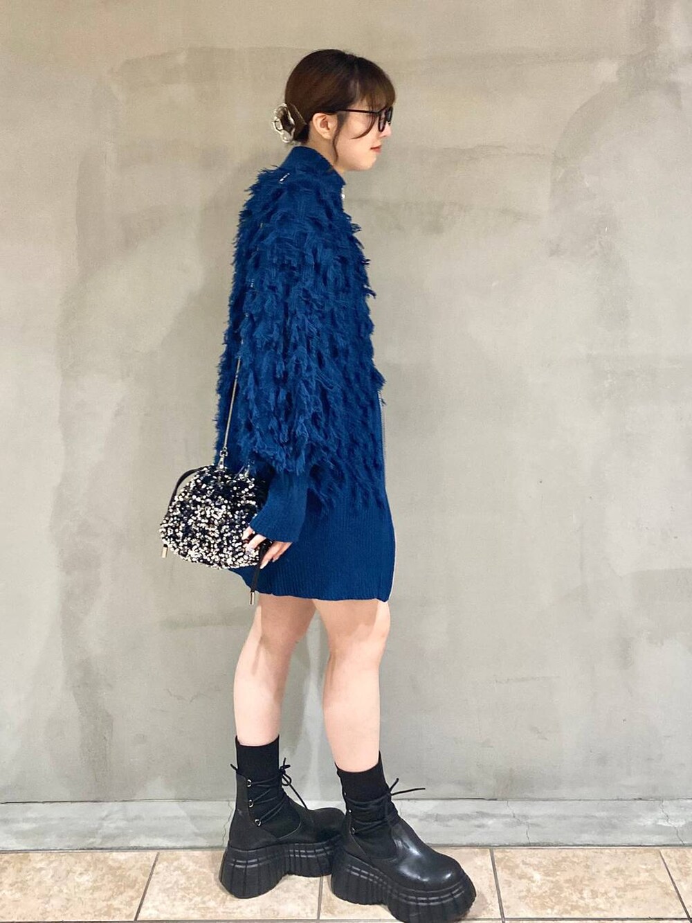 ブラック系のその他パンツ、ブラック系のブーツ、ブルー系のニット/セーターを着用したレディースの冬コーディネートの4枚目の写真