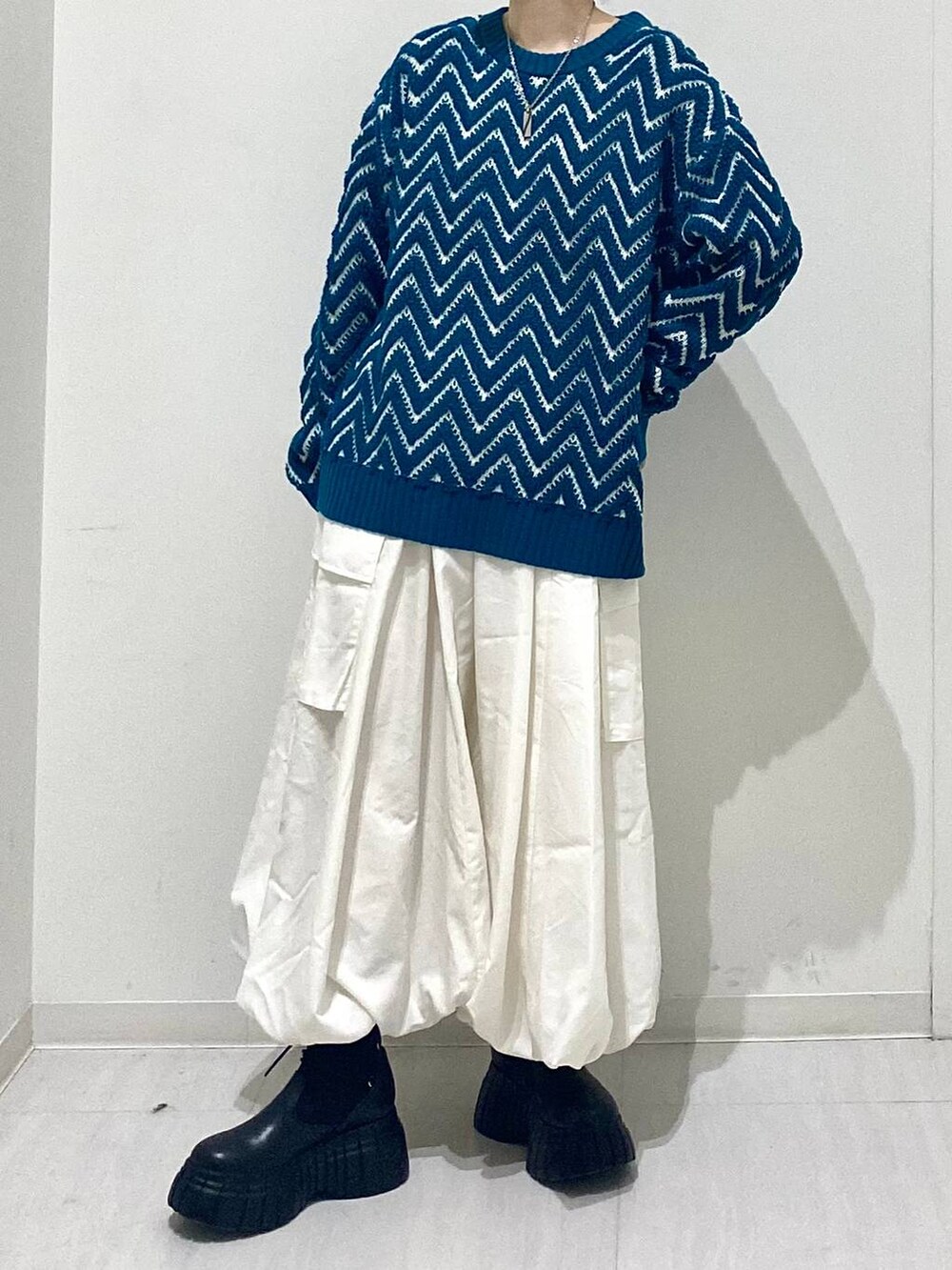 ブラック系のブーツ、ホワイト系のスカート、ブルー系のニット/セーターを着用したレディースの冬コーディネートの5枚目の写真