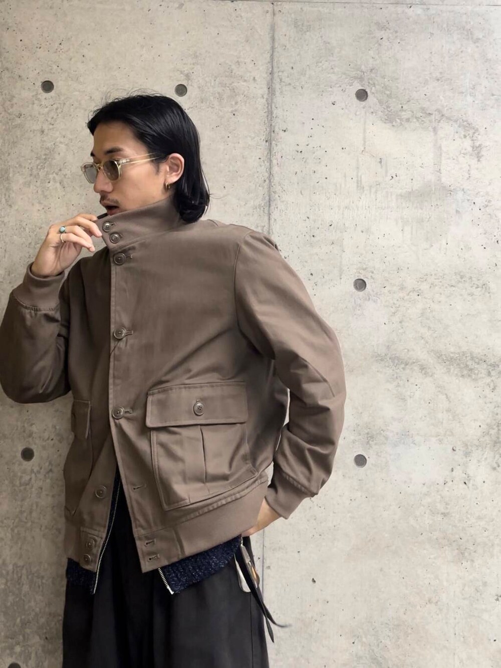 ブルー系のニット/セーター、ベージュ系のブルゾン、ブラック系のその他パンツを着用したメンズの秋コーディネートの2枚目の写真