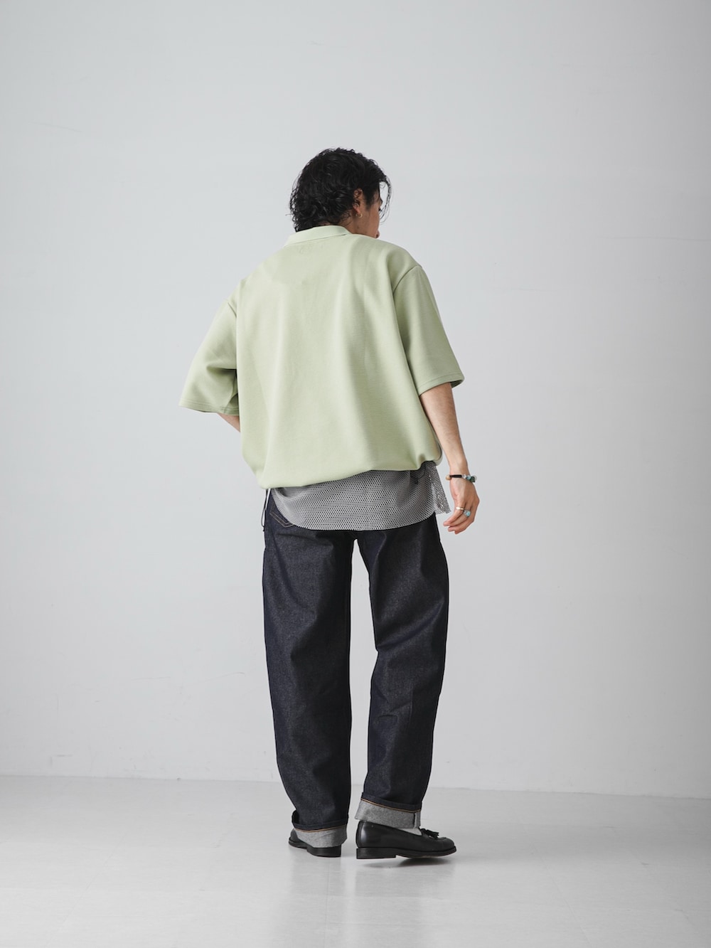 グリーン系のTシャツ/カットソー、グレー系のタンクトップ、ブルー系のデニムパンツを着用したメンズの夏コーディネートの6枚目の写真
