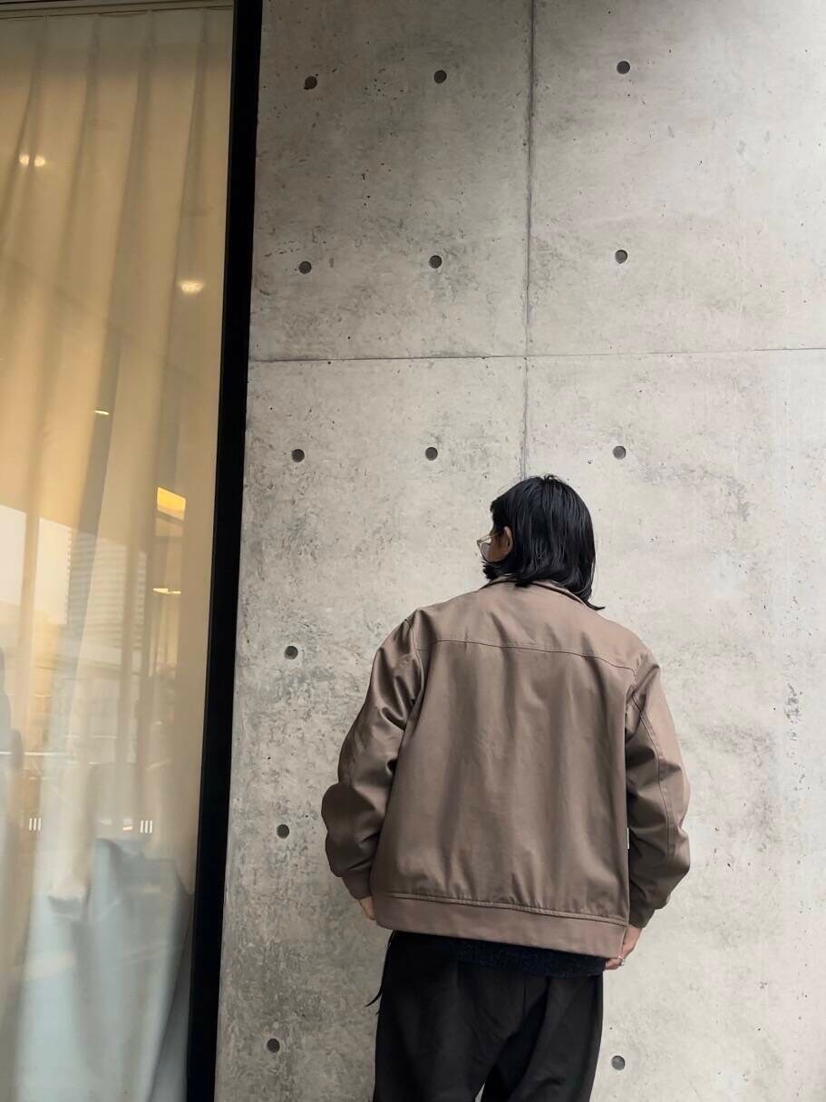 ブルー系のニット/セーター、ベージュ系のブルゾン、ブラック系のその他パンツを着用したメンズの秋コーディネートの4枚目の写真