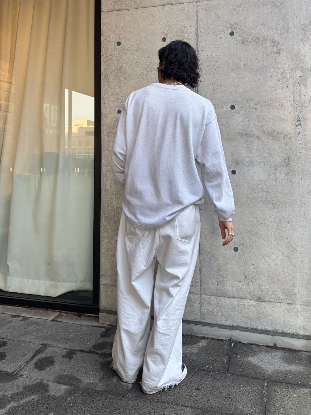 ホワイト系のニット/セーター、ブラウン系のスニーカーを着用したメンズの冬コーディネートの4枚目の写真