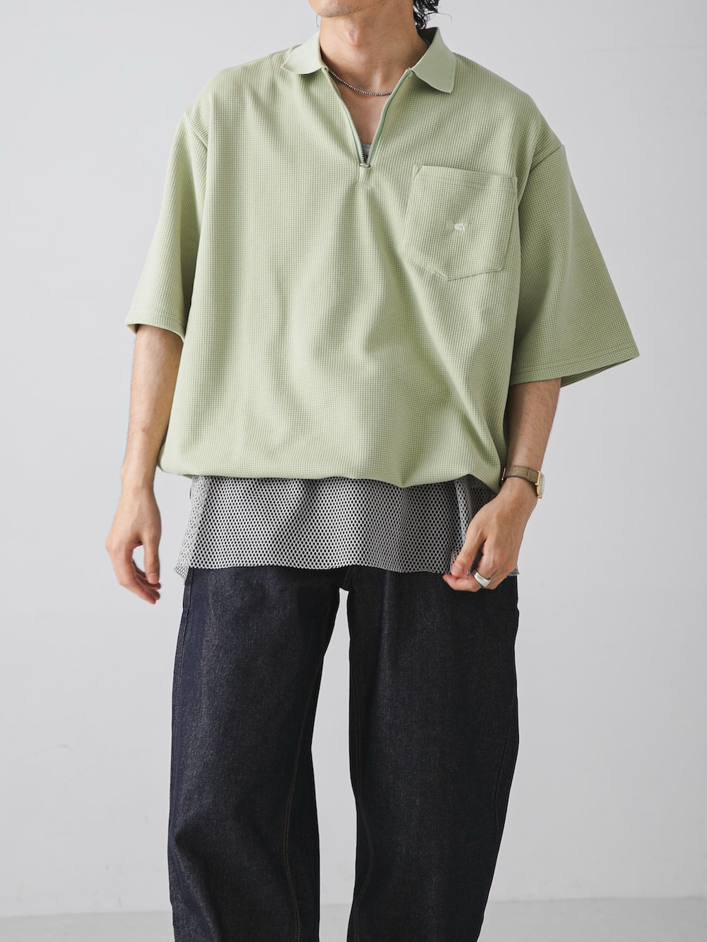グリーン系のTシャツ/カットソー、グレー系のタンクトップ、ブルー系のデニムパンツを着用したメンズの夏コーディネートの2枚目の写真