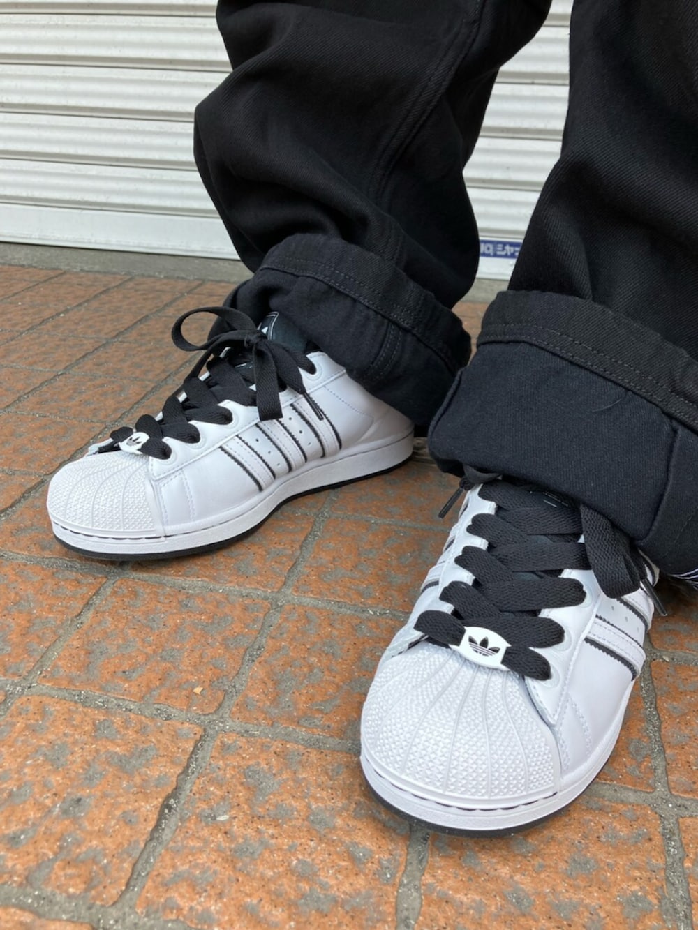 ブルー系のTシャツ/カットソー、ブラック系のデニムパンツ、ホワイト系のスニーカーを着用したメンズの春コーディネートの2枚目の写真