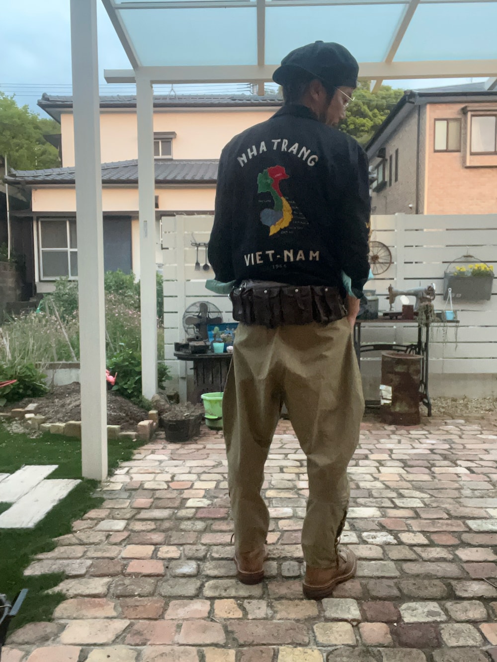 ブラウン系のブーツ、ベージュ系のカーゴパンツ、ブラウン系のボディバッグ/ウエストポーチを着用したメンズの春コーディネートの2枚目の写真