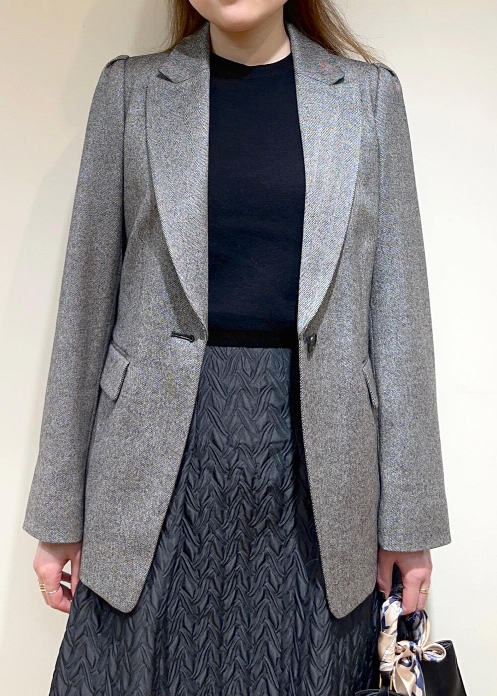 グレー系のテーラードジャケット、ブラック系のスカート、ブラック系のTシャツ/カットソーを着用したレディースの秋コーディネートの3枚目の写真