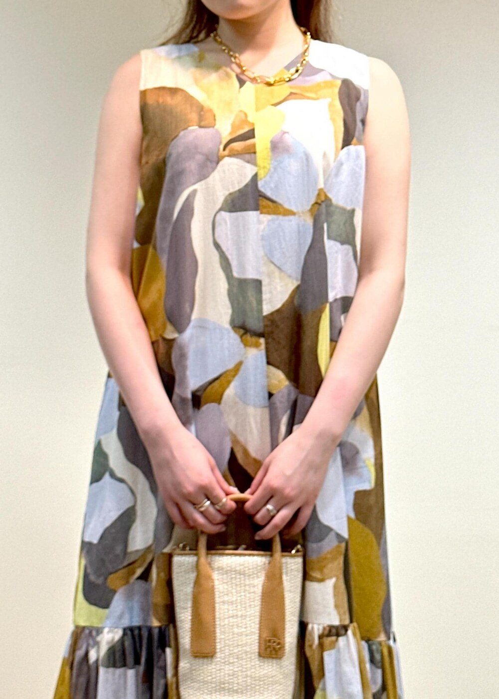 ホワイト系のサンダル、ベージュ系のハンドバッグ、ブルー系のワンピースを着用したレディースの夏コーディネートの4枚目の写真