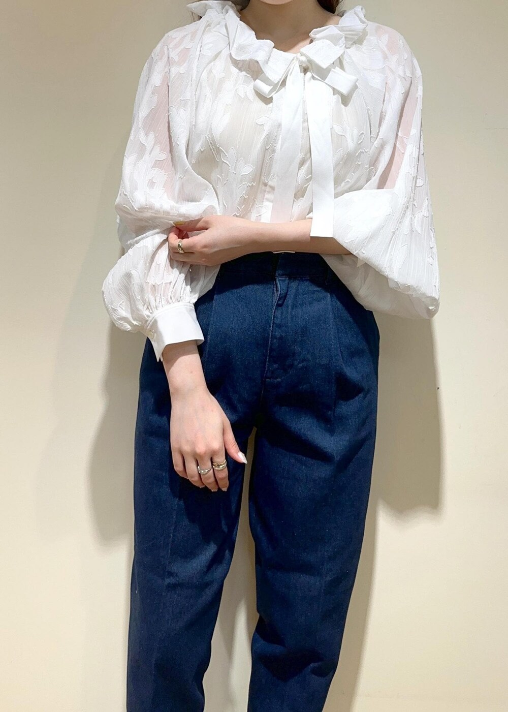 ベージュ系のショルダーバッグ、ブラック系のパンプス、ブルー系のデニムパンツを着用したレディースの夏コーディネートの4枚目の写真