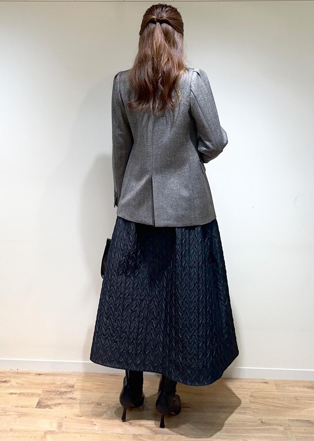 グレー系のテーラードジャケット、ブラック系のスカート、ブラック系のTシャツ/カットソーを着用したレディースの秋コーディネートの2枚目の写真