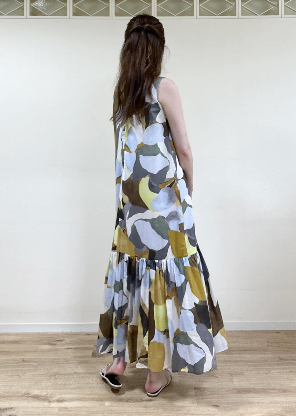 ホワイト系のサンダル、ベージュ系のハンドバッグ、ブルー系のワンピースを着用したレディースの夏コーディネートの3枚目の写真