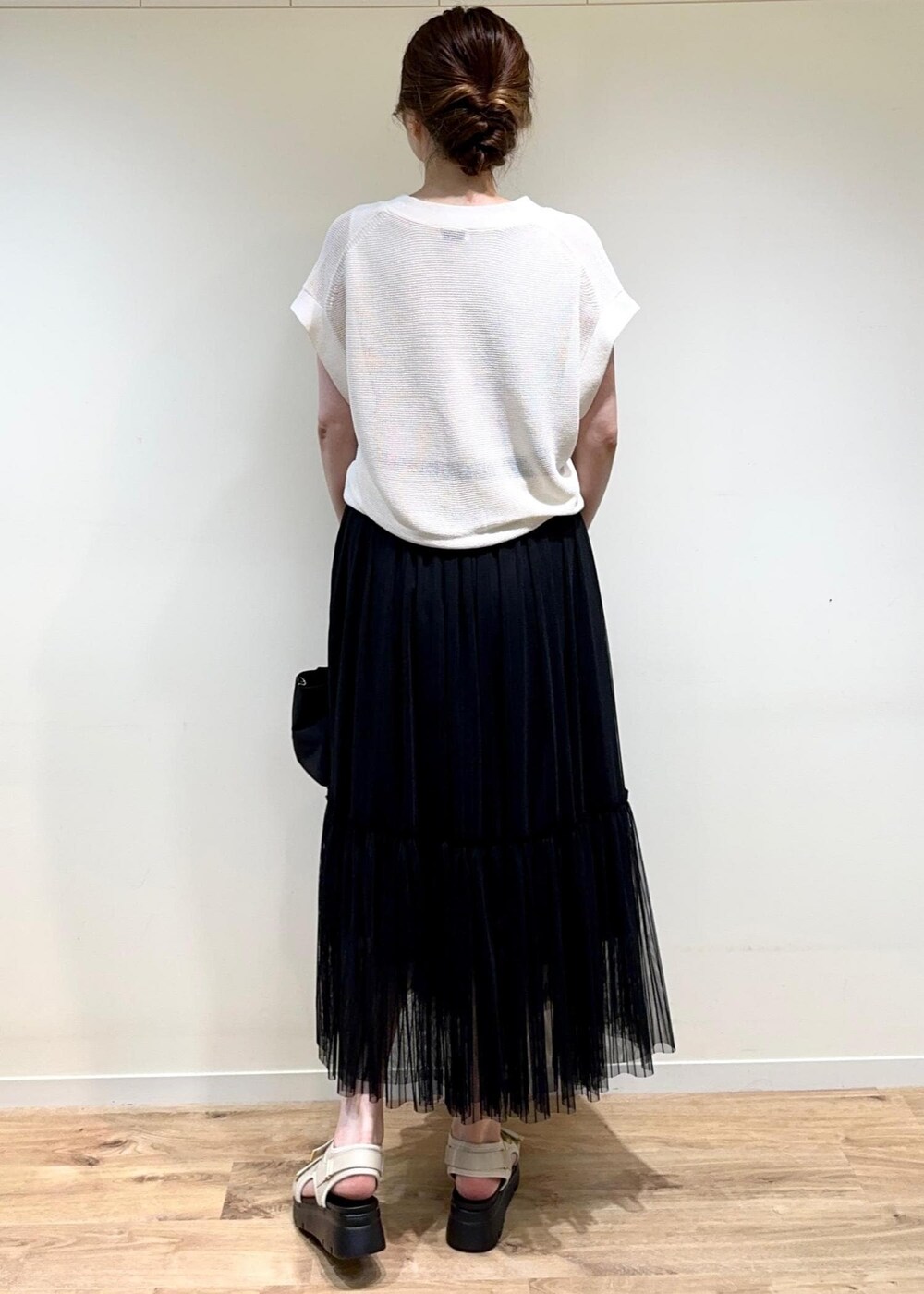 ホワイト系のサンダル、ブラック系のトートバッグ、ブラック系のスカートを着用したレディースの夏コーディネートの2枚目の写真