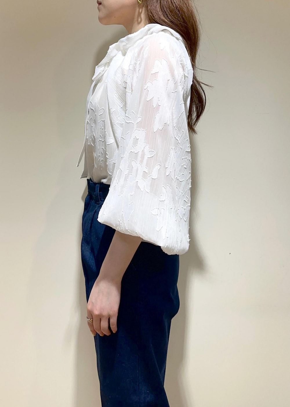 ベージュ系のショルダーバッグ、ブラック系のパンプス、ブルー系のデニムパンツを着用したレディースの夏コーディネートの3枚目の写真