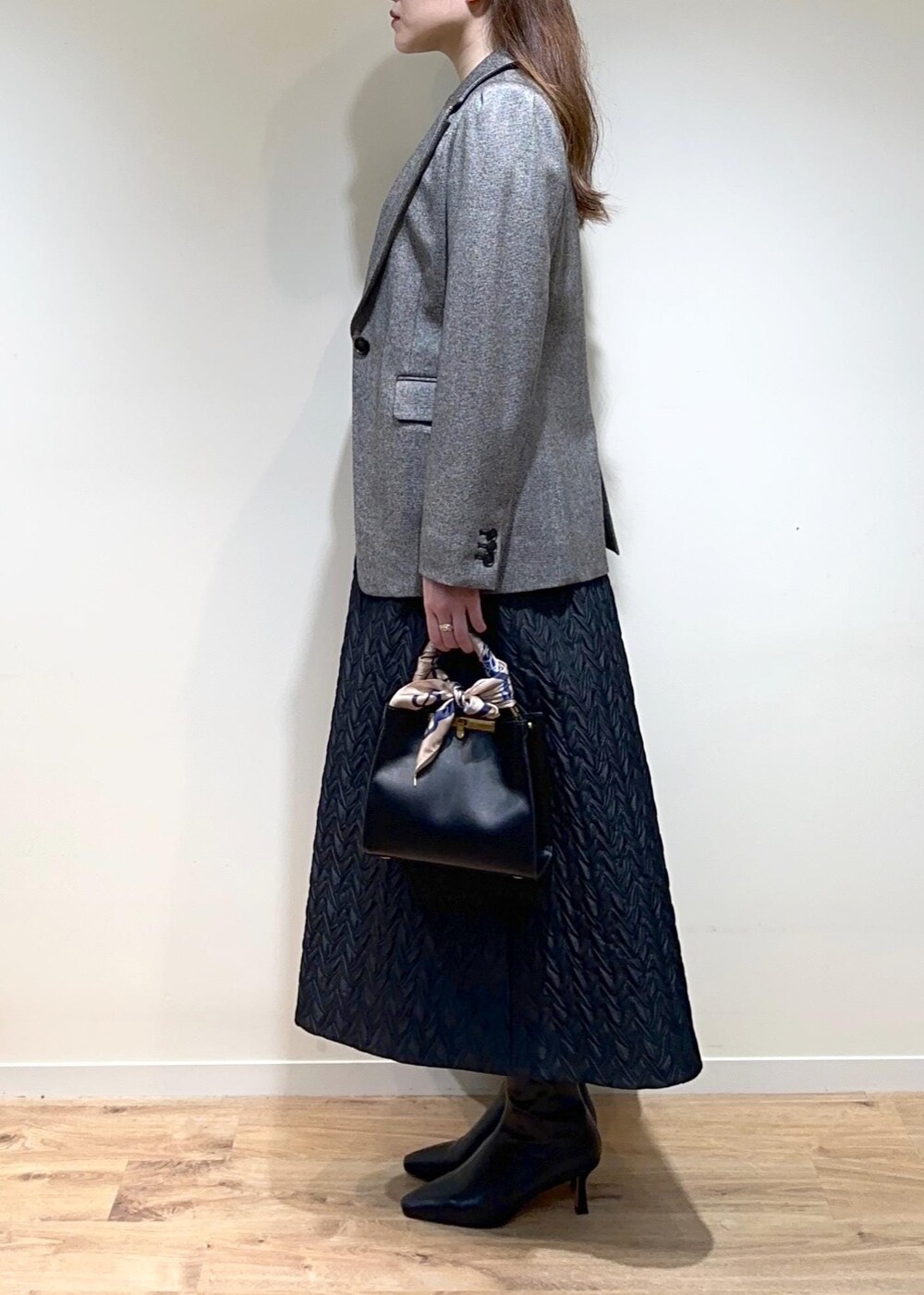 グレー系のテーラードジャケット、ブラック系のスカート、ブラック系のTシャツ/カットソーを着用したレディースの秋コーディネートの4枚目の写真