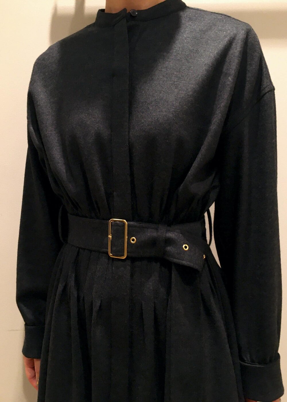 ホワイト系のハンドバッグ、ブラック系のブーツ、グレー系のワンピースを着用したレディースの冬コーディネートの5枚目の写真