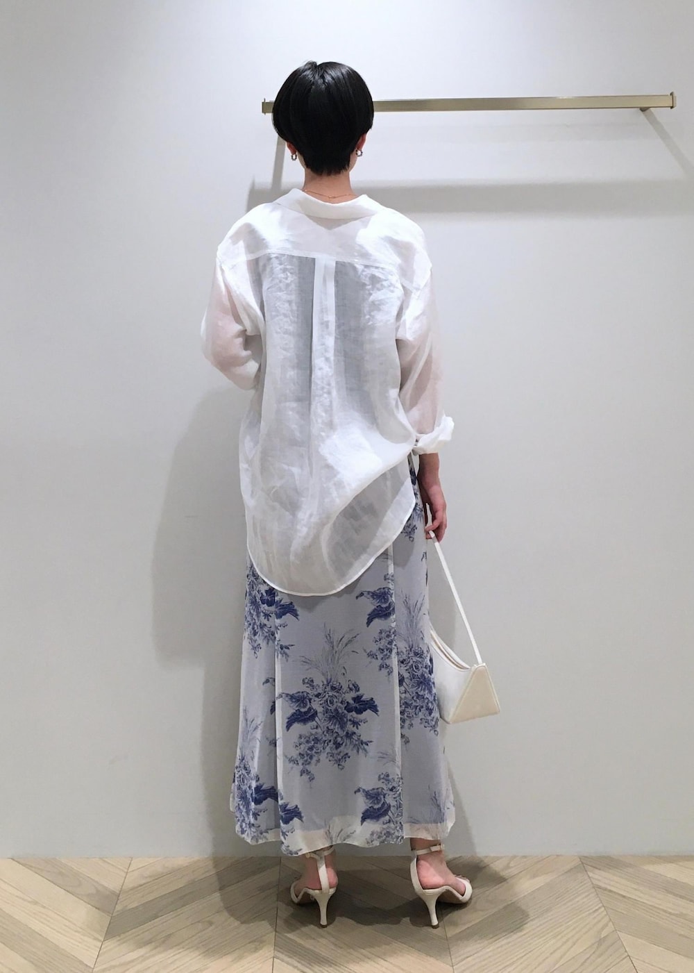 ホワイト系のハンドバッグ、ホワイト系のサンダル、ホワイト系のシャツ/ブラウスを着用したレディースの春コーディネートの3枚目の写真