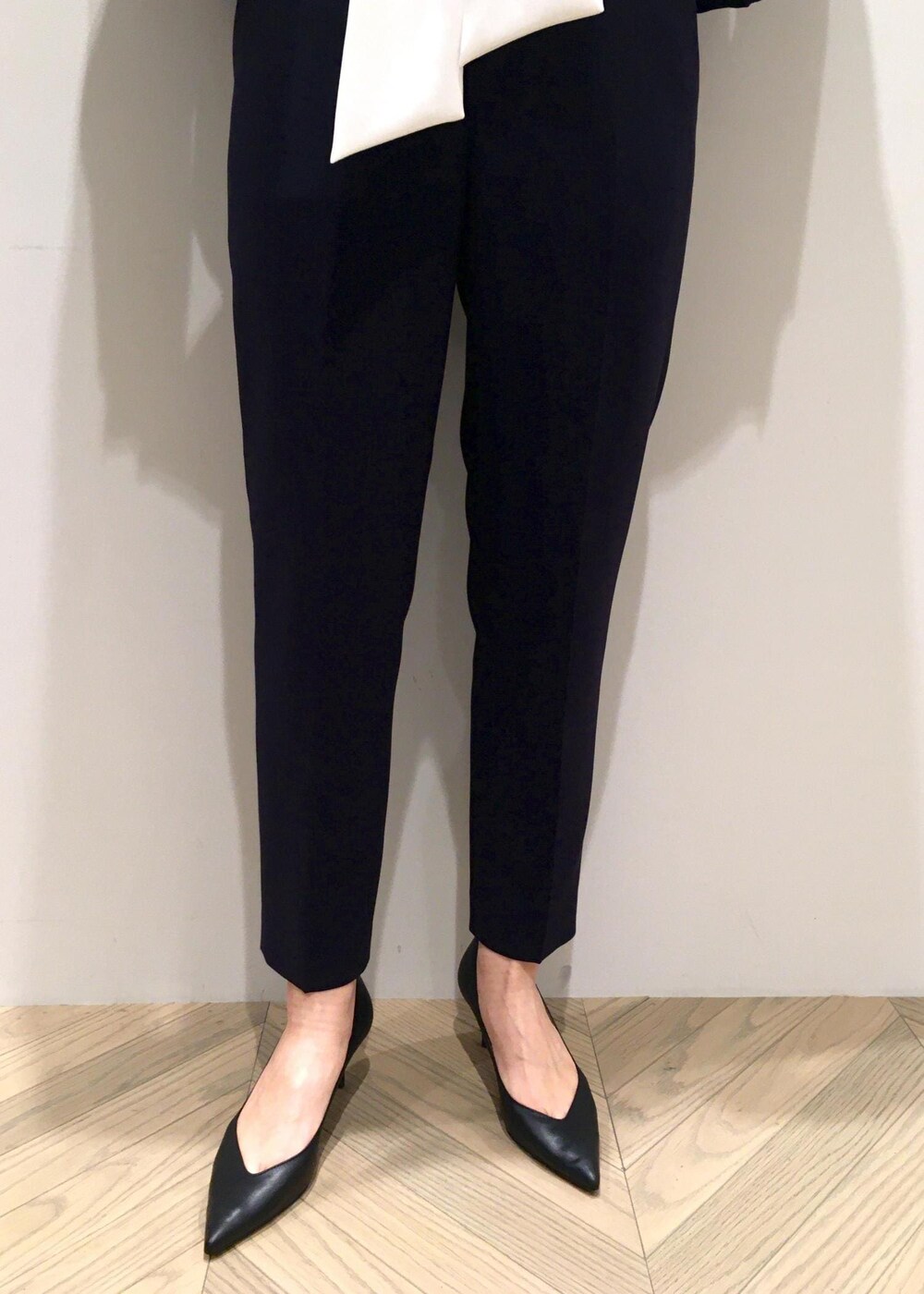 ブラック系のパンプス、ブラウン系のハンドバッグ、ブルー系のノーカラージャケットを着用したレディースの冬コーディネートの5枚目の写真