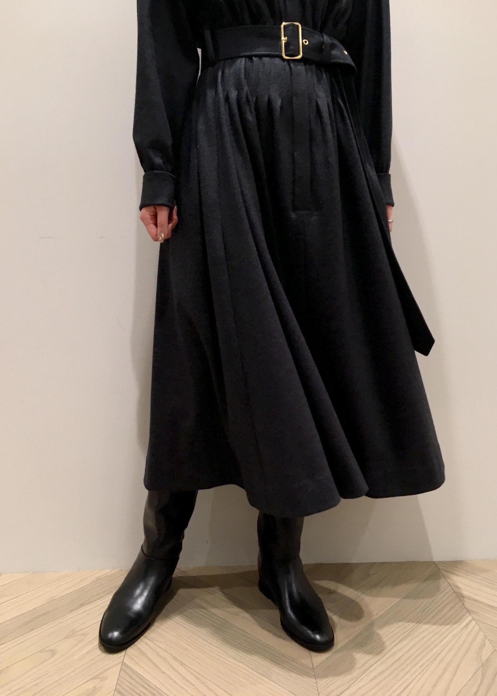 ホワイト系のハンドバッグ、ブラック系のブーツ、グレー系のワンピースを着用したレディースの冬コーディネートの6枚目の写真