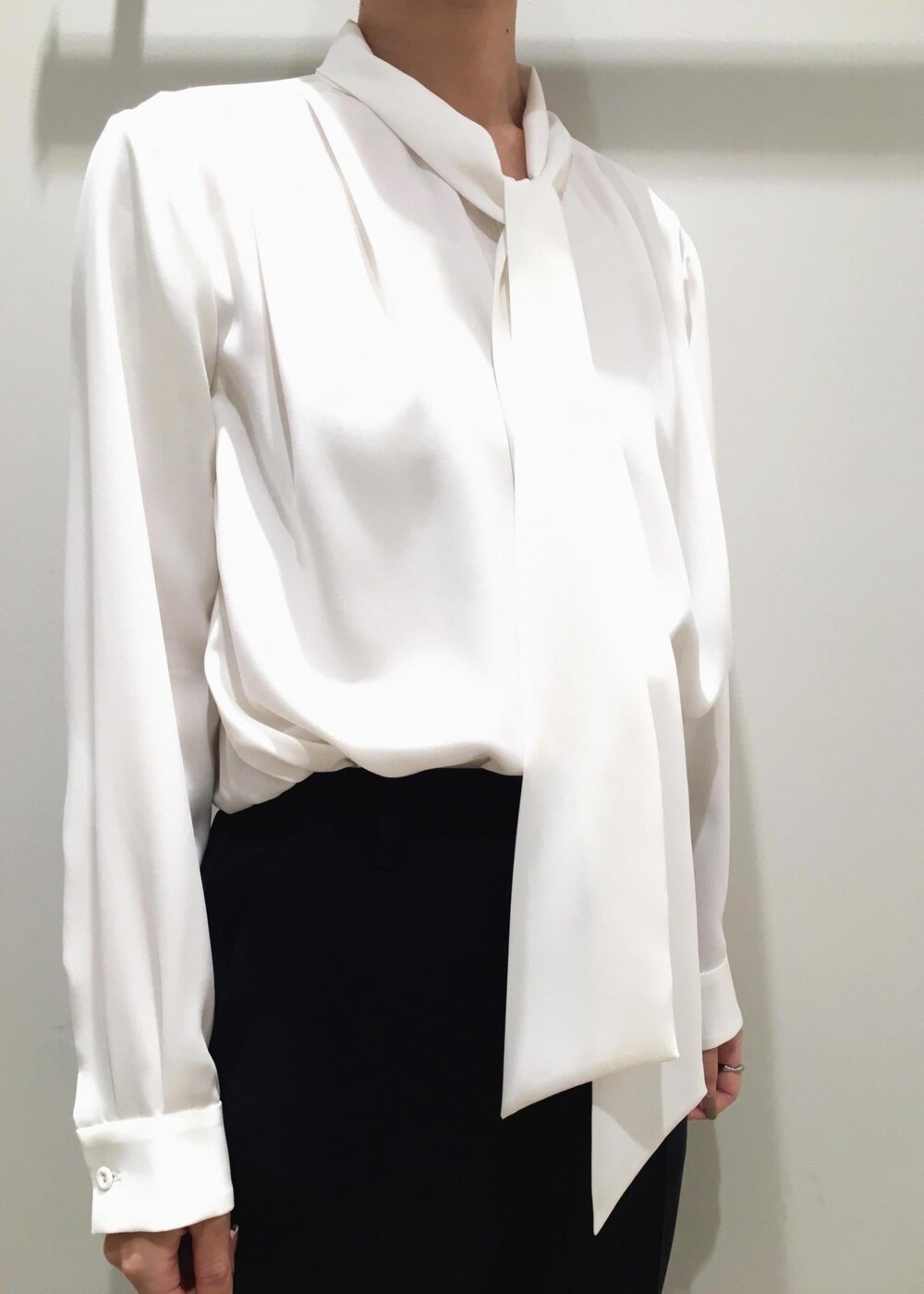 ブラック系のパンプス、ブラウン系のハンドバッグ、ブルー系のノーカラージャケットを着用したレディースの冬コーディネートの4枚目の写真