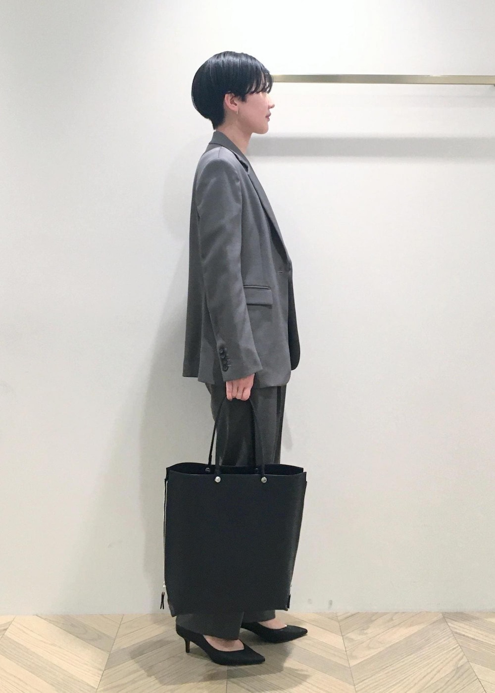 ブラック系のパンプス、ホワイト系のTシャツ/カットソー、グレー系のその他パンツを着用したレディースの春コーディネートの3枚目の写真