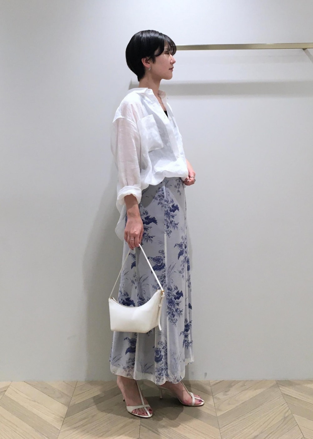 ホワイト系のハンドバッグ、ホワイト系のサンダル、ホワイト系のシャツ/ブラウスを着用したレディースの春コーディネートの2枚目の写真