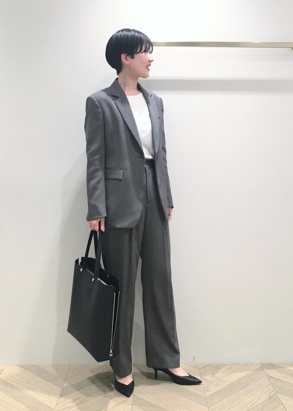 ブラック系のパンプス、ホワイト系のTシャツ/カットソー、グレー系のその他パンツを着用したレディースの春コーディネートの2枚目の写真