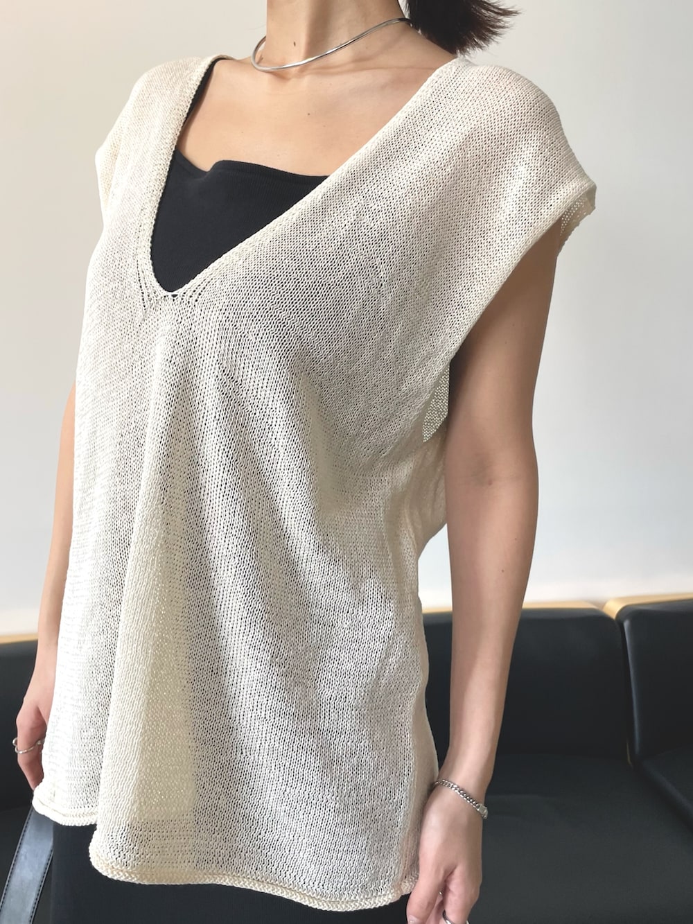 ホワイト系のベスト、ブラック系のワンピースを着用したレディースの春コーディネートの3枚目の写真